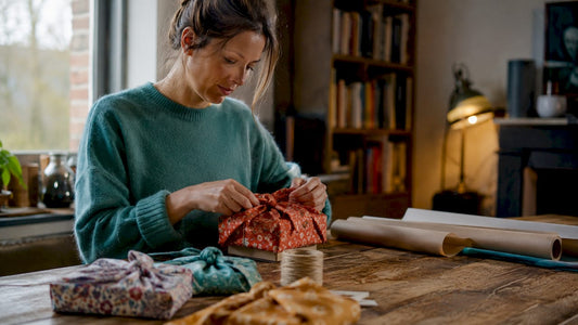 In de keuken wikkelt een vrouw een cadeau in met de traditionele Furoshiki doeken.